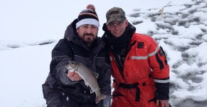Deux homme montrant leur prise de truite en pêche blanche sur le Lac Témiscouata
